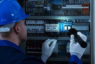An electrician inspecting a faulty safety switch