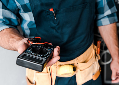 An electrician holding a voltmeter